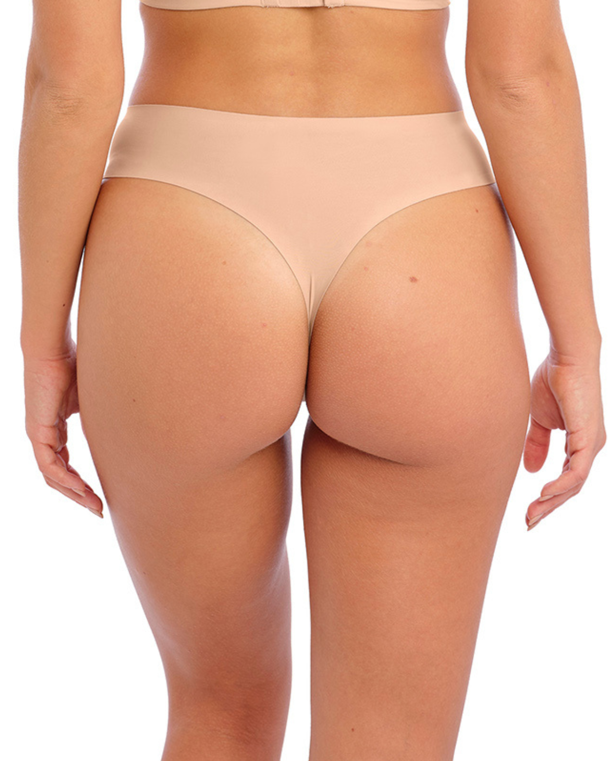 Model wearing a seamless thong in beige/ nude