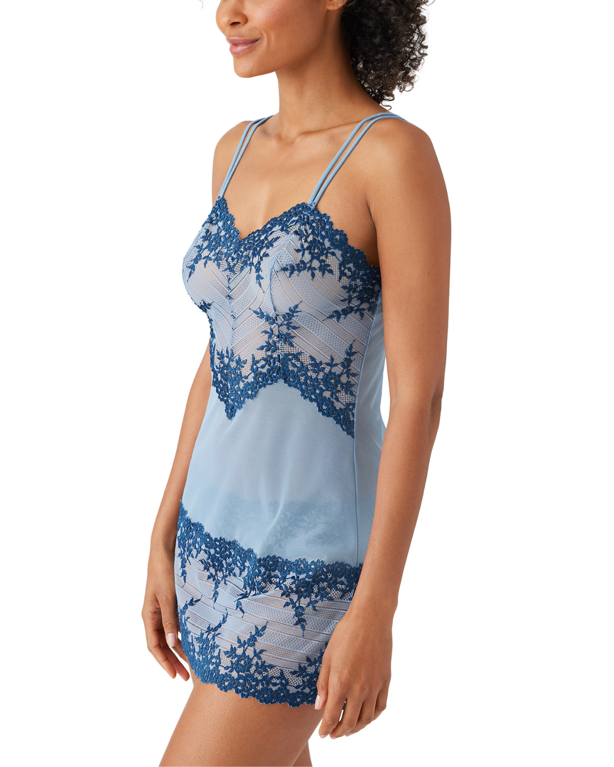 Model wearing a lace chemise with floral details in blue and navy