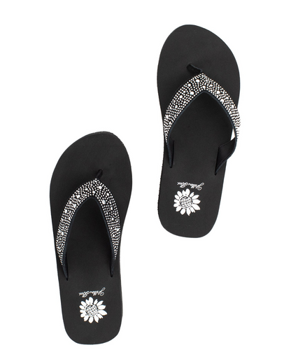 Top view of a pair of black wedge sandal with rhinestones on the strap on a white backdrop.