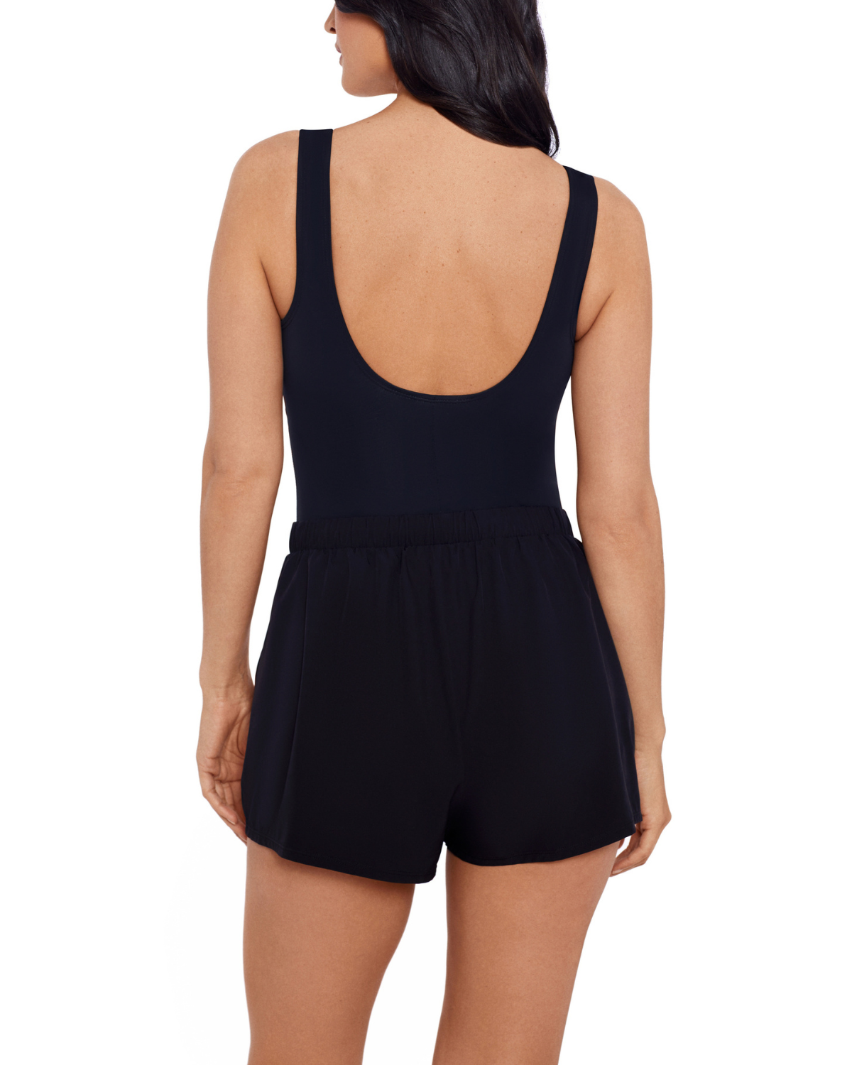 Model wearing a jogger short one piece with pockets in black with blue dots on the top and scoop back.