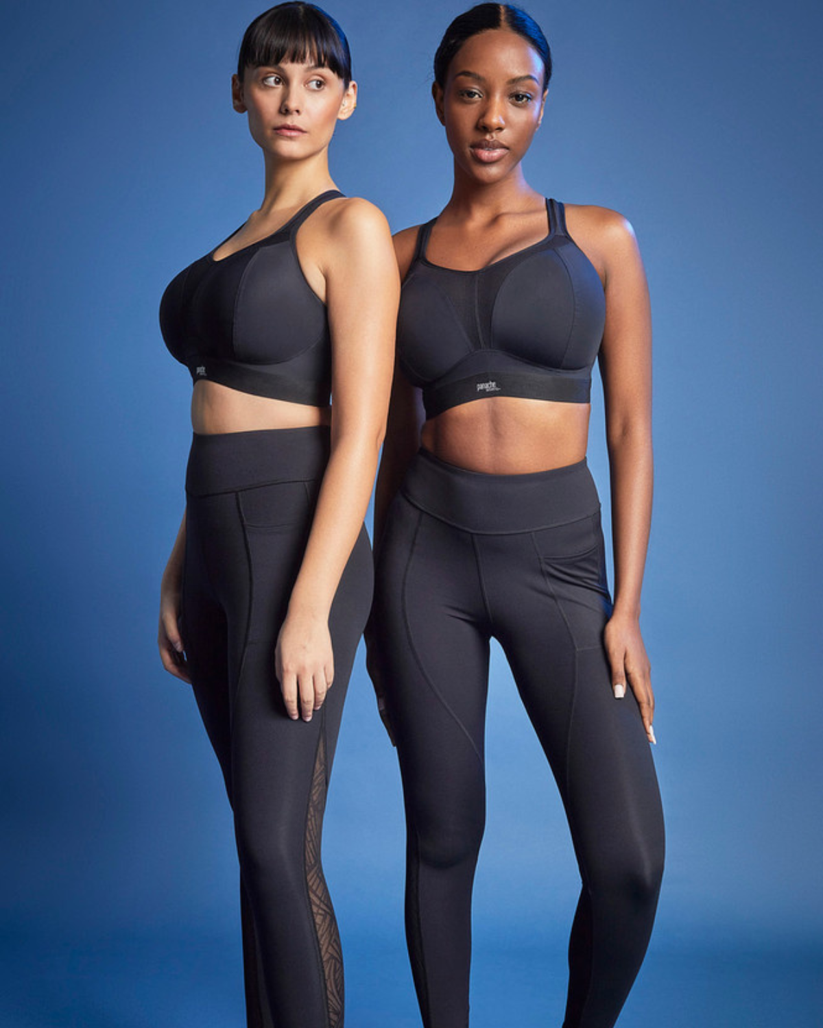 Two models wearing matching wire free sports bras in black paired with black leggings