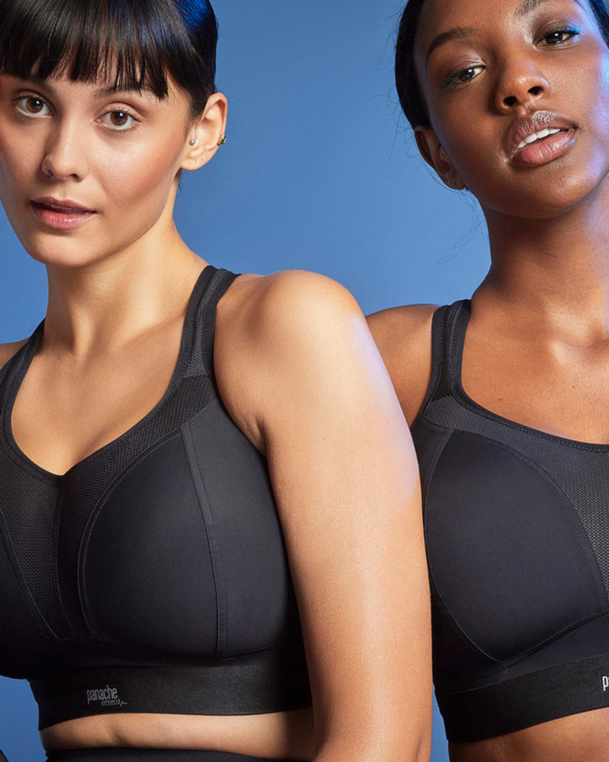 Two models wearing matching wire free sports bras in black paired with black leggings