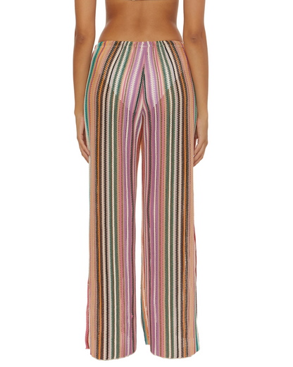 Model wearing a split multi-way cover up pant with adjustable ties at the ankle in a striped red, green, white, pink and orange print