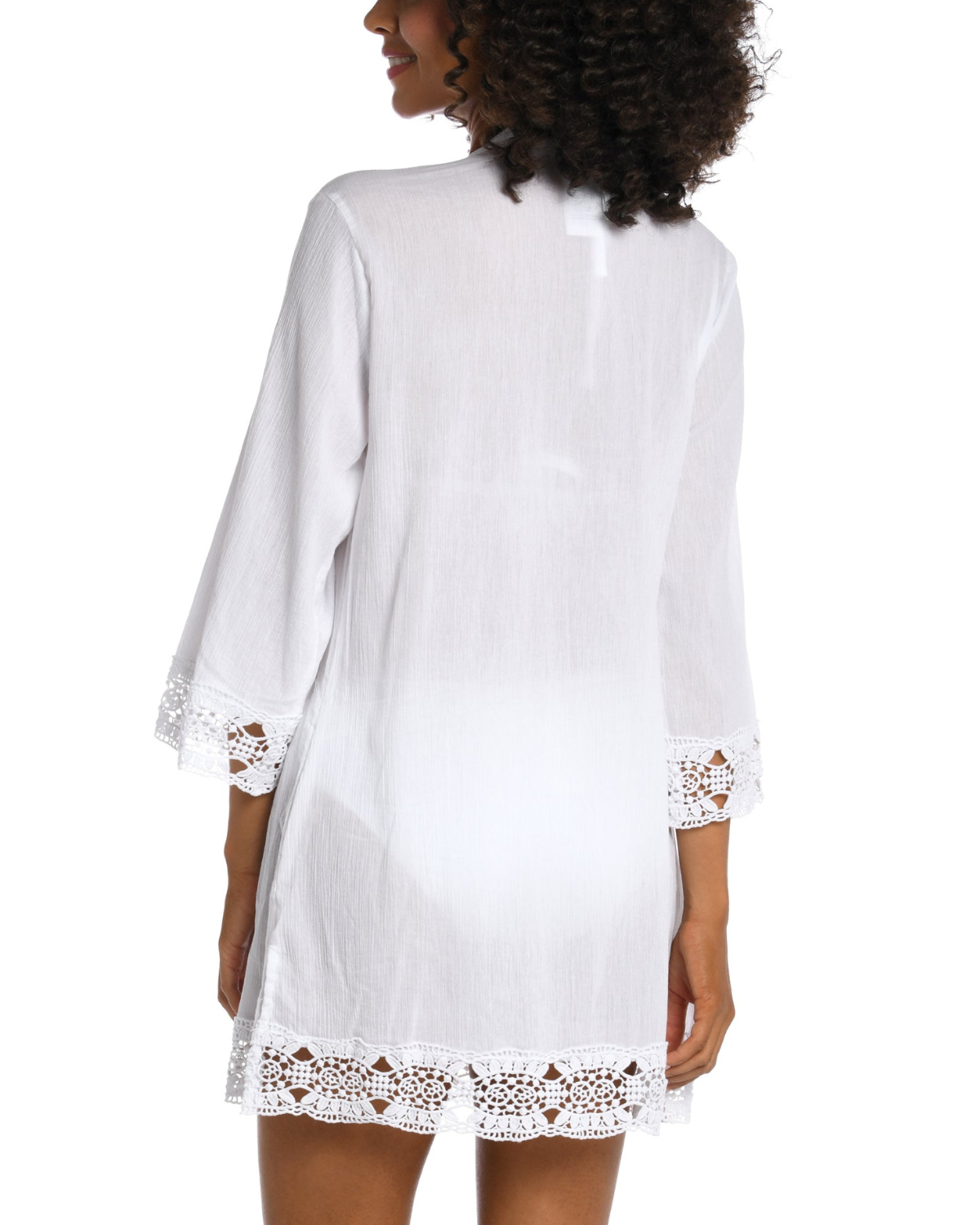 Model wearing a 3/4 sleeve v-neck tunic with a crochet trim in white