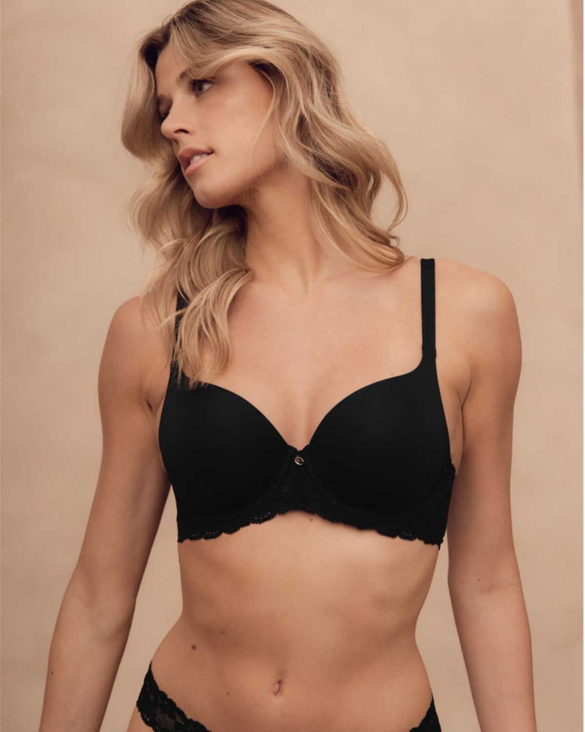 Model wearing a molded t-shirt underwire bra with lace side wings in black