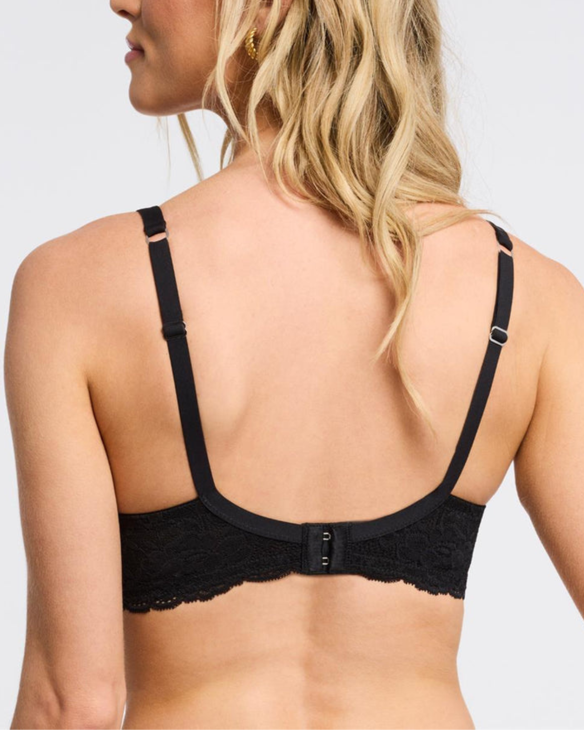 Model wearing a molded t-shirt underwire bra with lace side wings in black