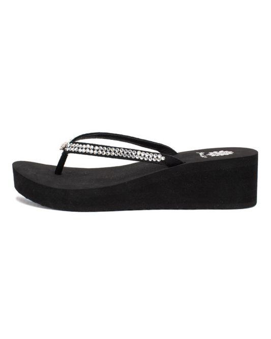 Front side view of a black wedge sandal with rhinestones on the strap on a white backdrop. The sandal has 1.75" heel height and 0.75" platform height.