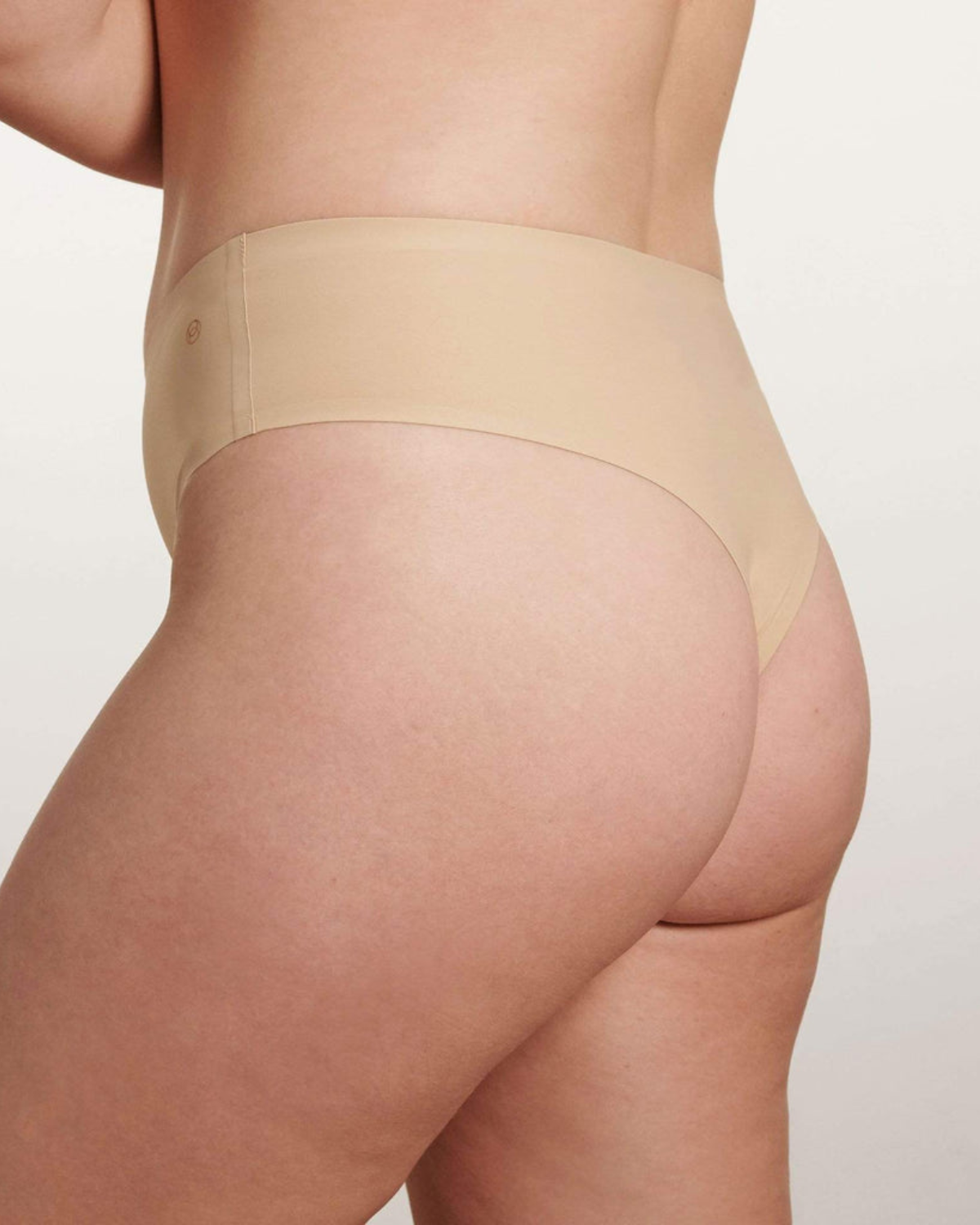 Model wearing a light nude high waist seamless thong