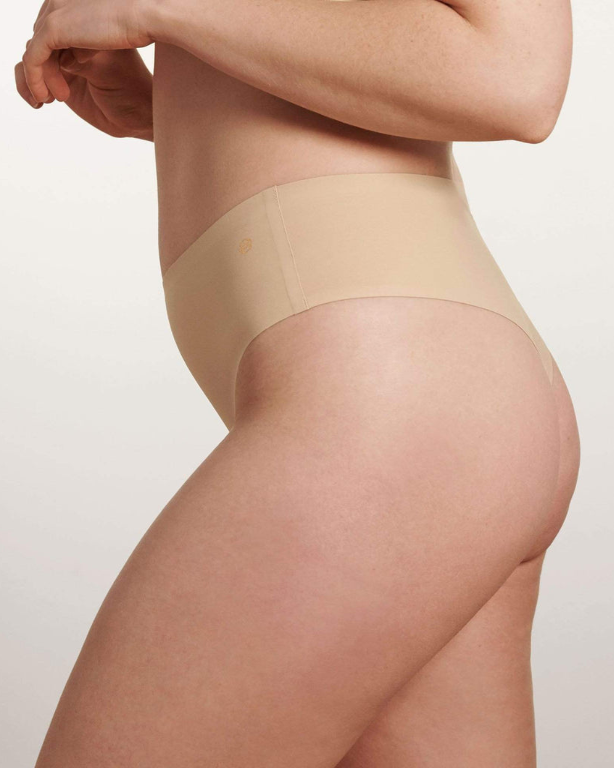 Model wearing a light nude high waist seamless thong