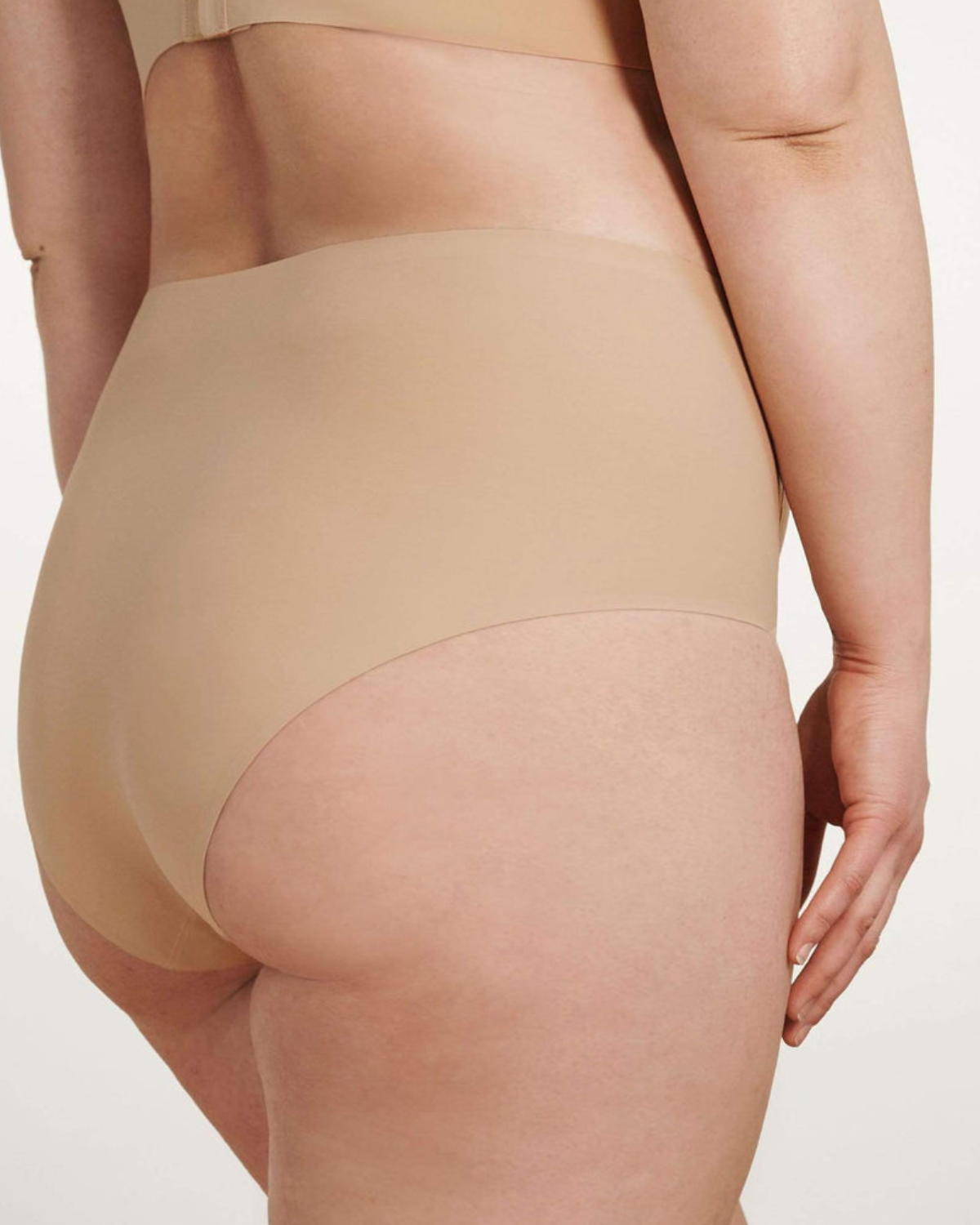 Model wearing a light nude high waist seamless brief panty