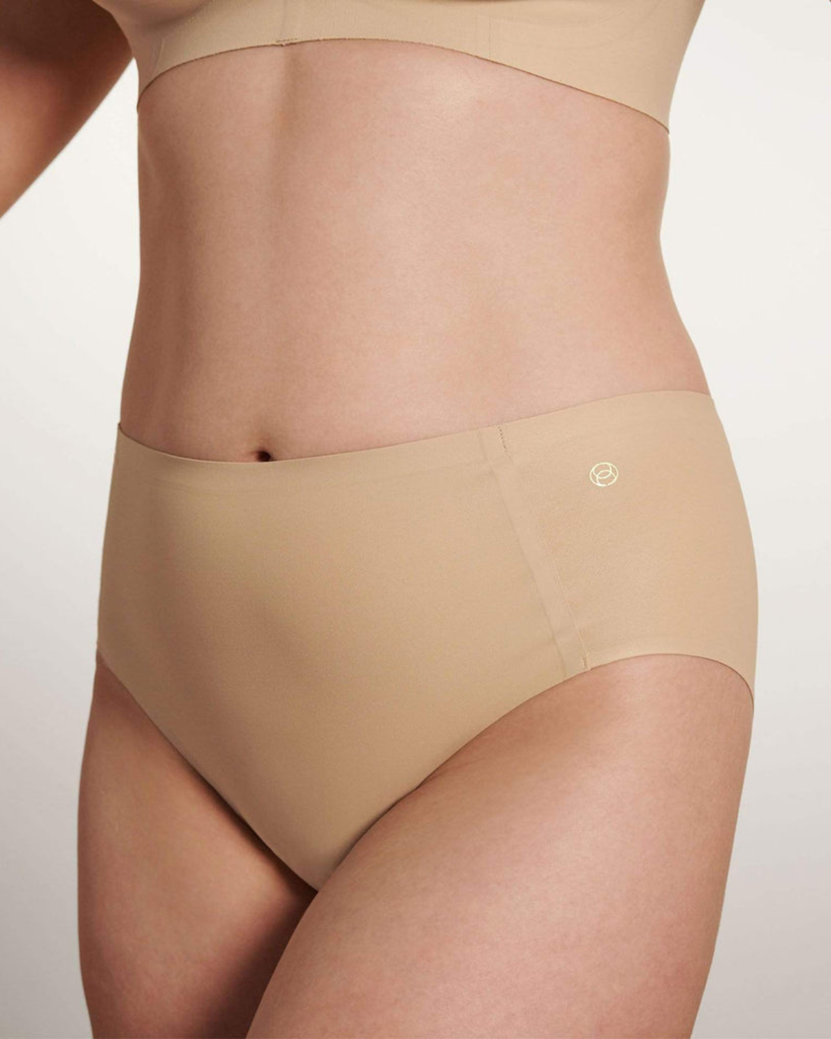 Model wearing a light nude high waist seamless brief panty