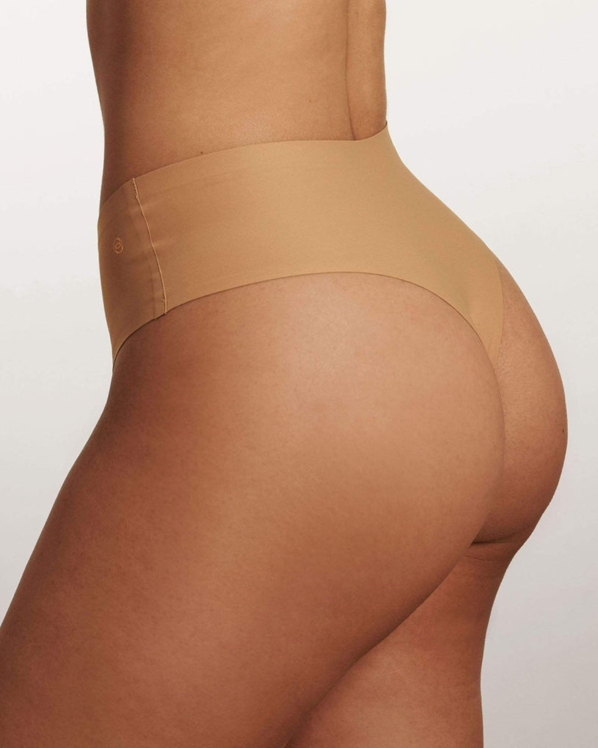 Model wearing a medium nude high waist seamless thong