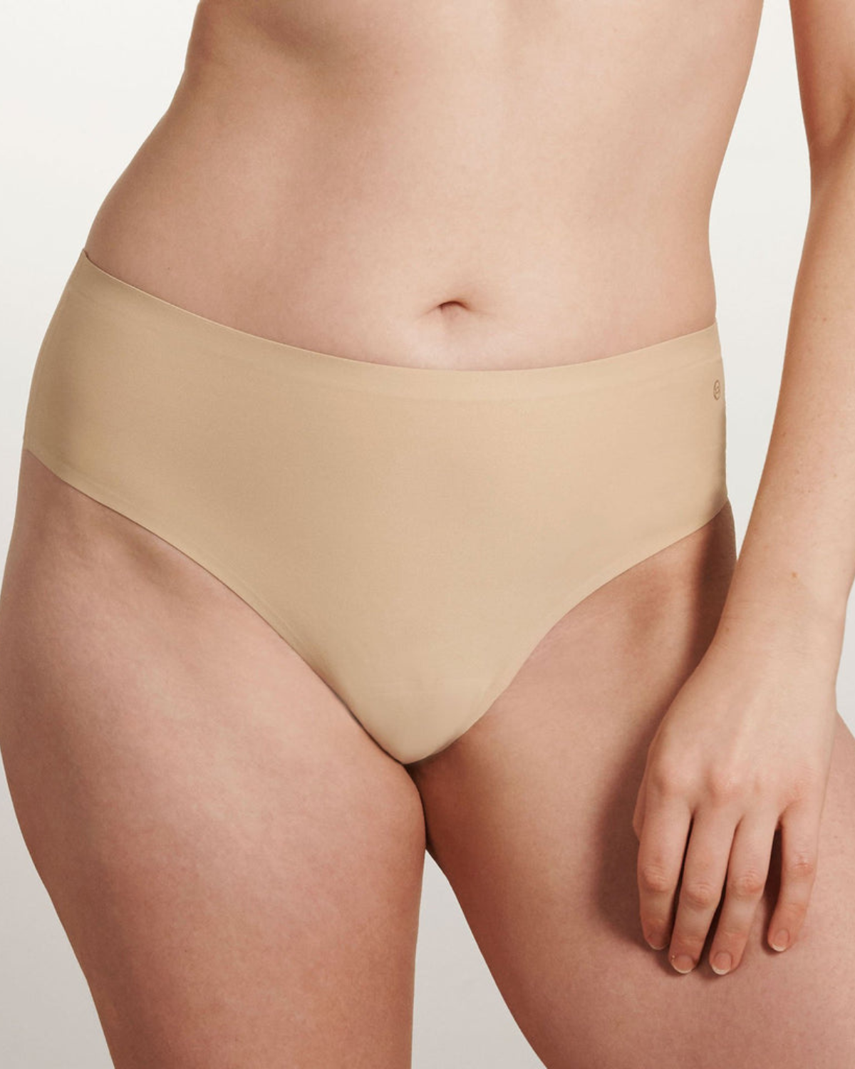 Model wearing a light nude high waist seamless thong