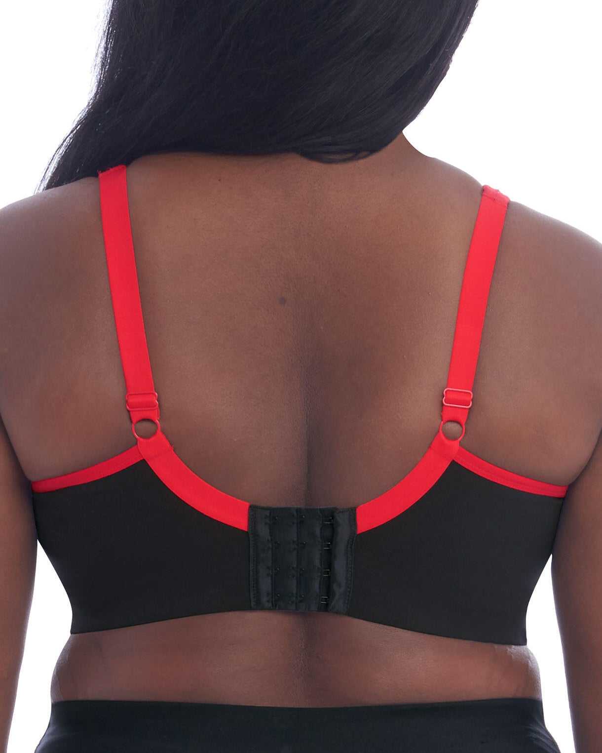 Model wearing a wire free sports bra in black with a red trim