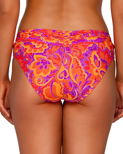 Model wearing a hipster bikini bottom in a red, purple, orange and yellow paisley print