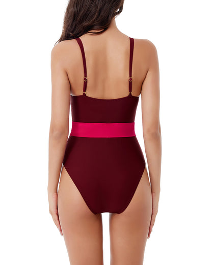 Model wearing a one piece with a tie waist detail in a colorblock pattern with maroon, pink and hot pink