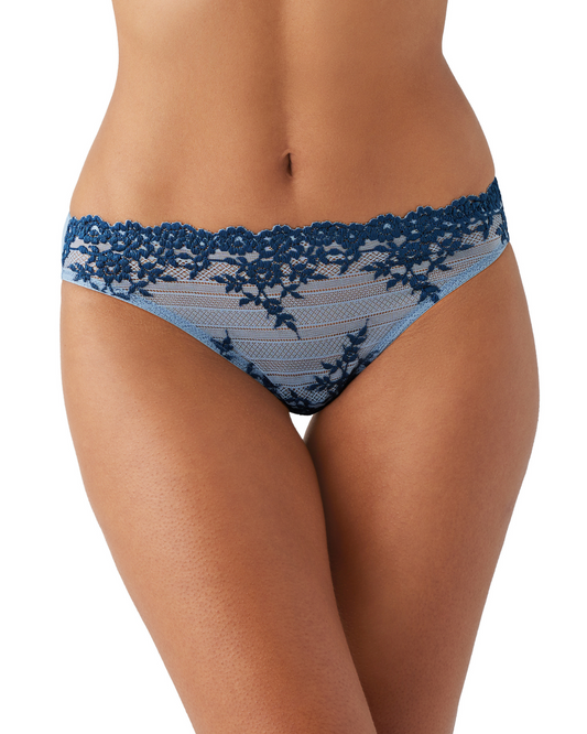 Model wearing a bikini brief in blue and navy floral lace