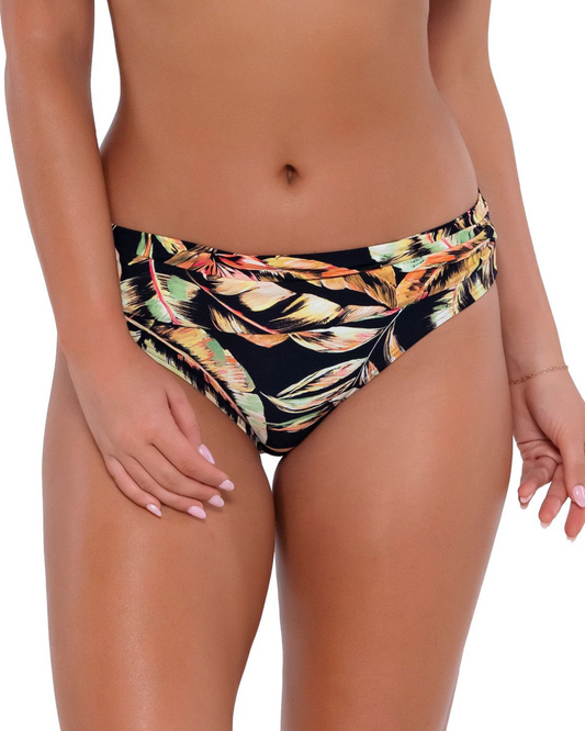 Model wearing a hipster bikini bottom in a black, green and red tropical print.