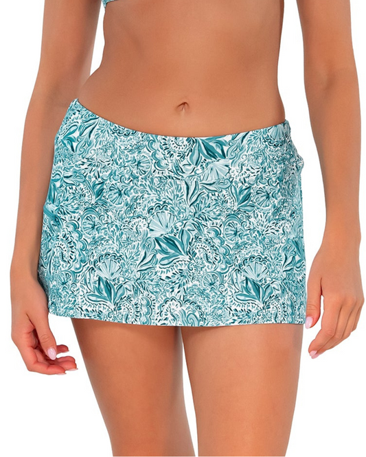 Model wearing a swim skirt with side pocket and hidden shorts in a pale turquoise, white and navy paisley print