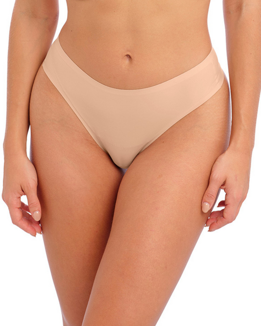 Model wearing a seamless thong in beige/ nude