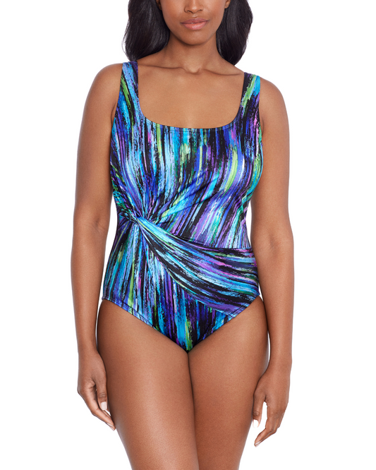 Model wearing a twist drape one piece swimwuit in a multi colored black, buye, purple and green abstract paint streak print