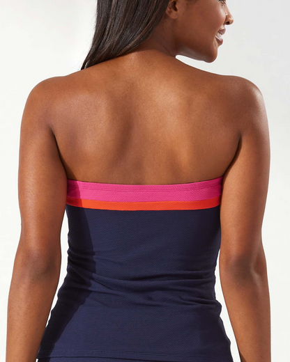 Model wearing a bandeau tankini top in navy with pink and orange stripes at the neckline