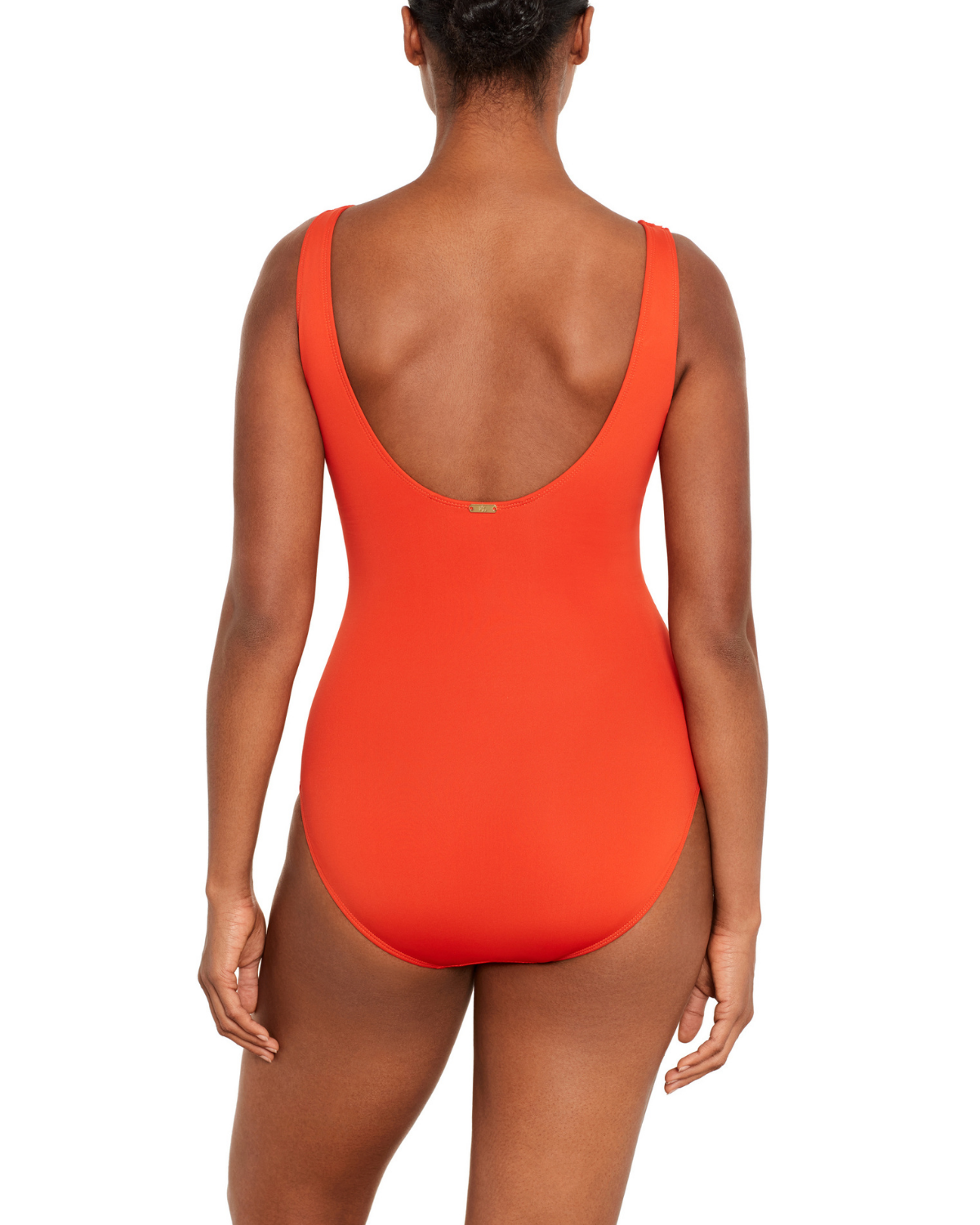 Model wearing a v-neck one piece with a ruffle trim and shirred panel around the torso in orange
