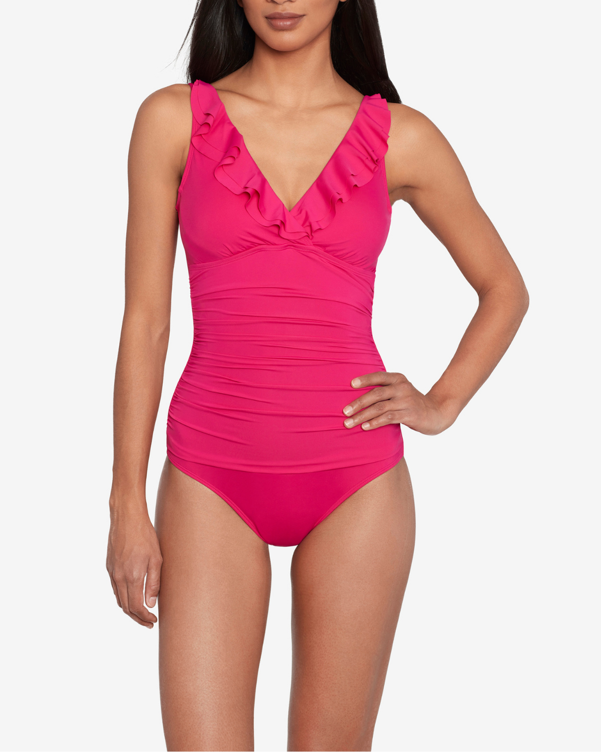 Model wearing a v-neck one piece with a ruffle trim and shirred panel around the torso in pink