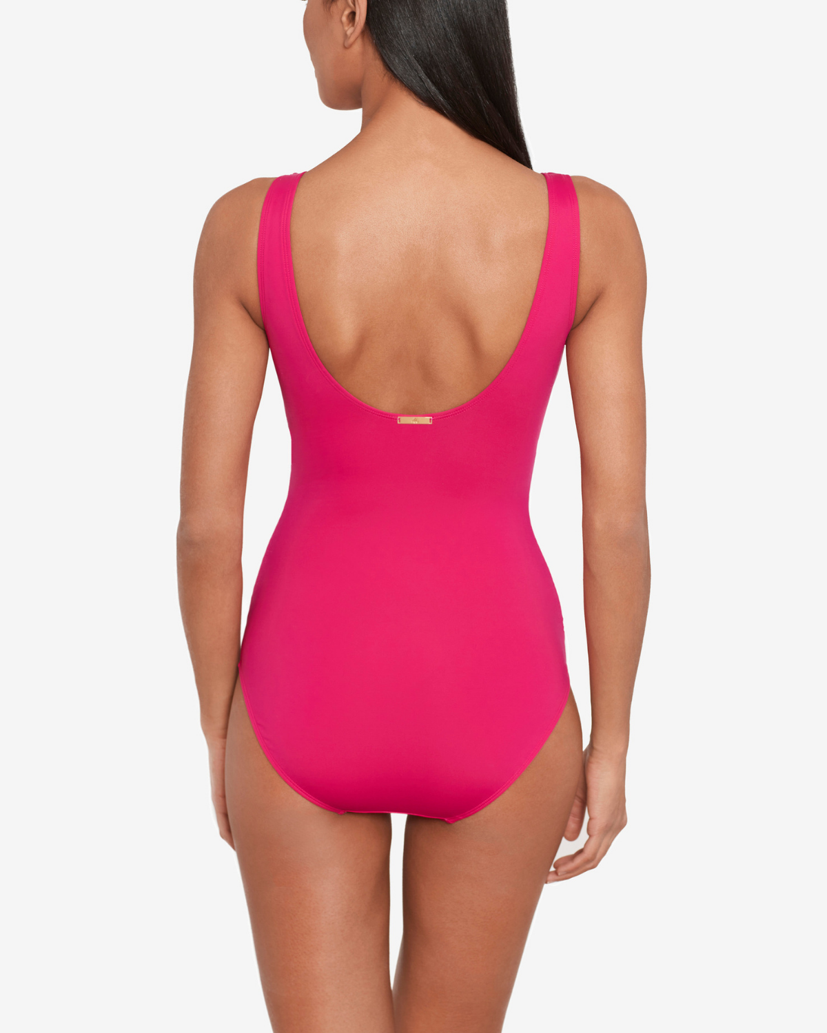 Model wearing a v-neck one piece with a ruffle trim and shirred panel around the torso in pink