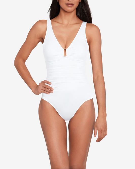 Model wearing a v-neck one piece with a ring detail and shirred torso in white