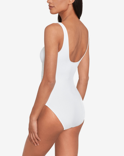 Model wearing a v-neck one piece with a ring detail and shirred torso in white