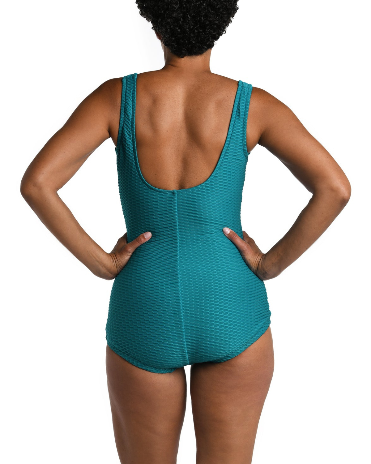 Model wearing a textured one piece swimsuit with a girl leg cut in emerald