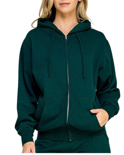 Model on a white backdrop wearing a women's oversized fleece zip up hooded sweater in solid forest green