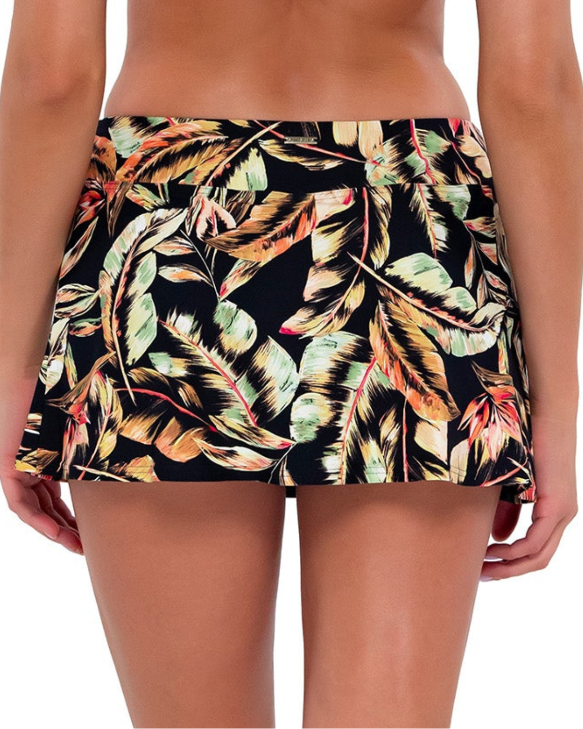 Model wearing a swim skirt with side pocket and hidden short in a black, green and red tropical print.