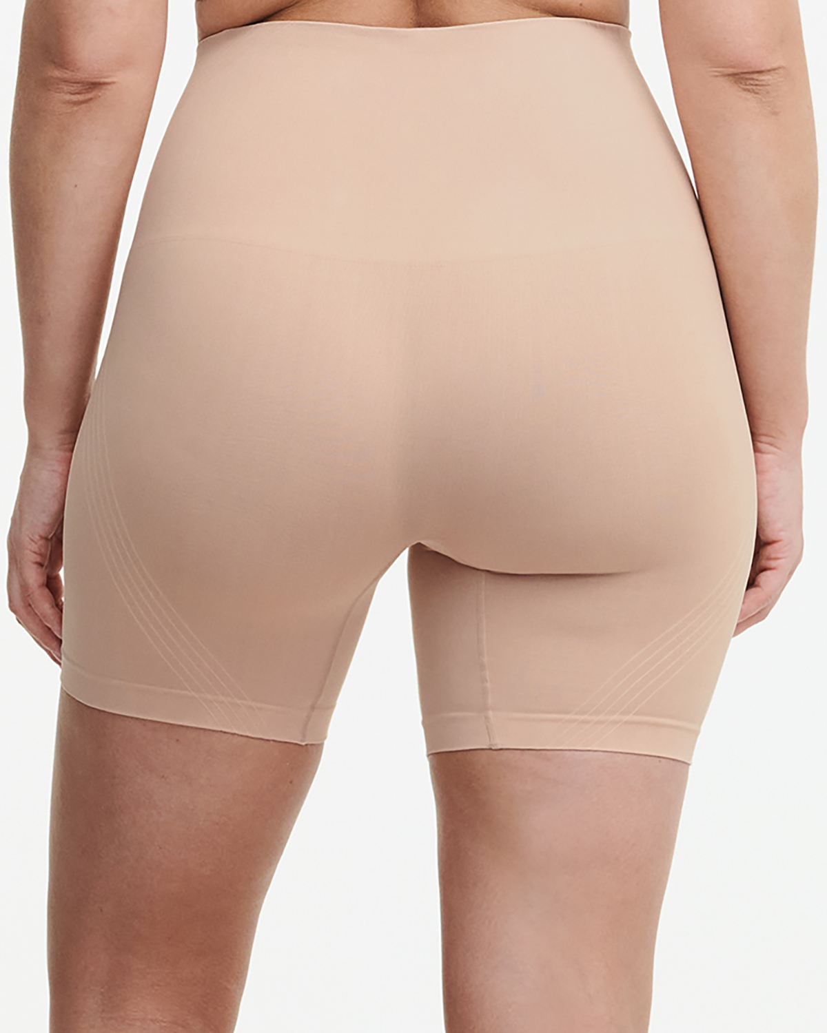 Model wearing a high waist mid thigh shaping short in beige