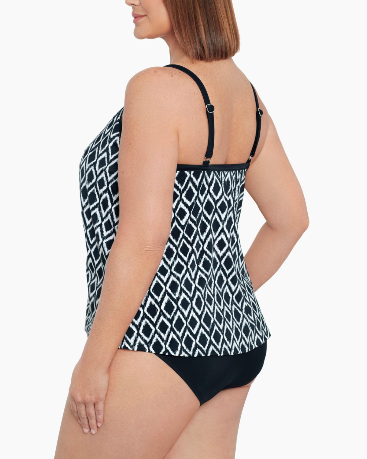 Model wearing a plus size flyaway tankini top in a black and ivory ikat print