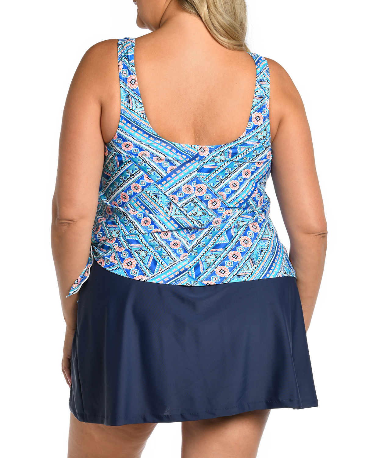 Model wearing a faux tankini skirted one piece swimsuit with a blue, navy and tellow mediterranean print top and navy skirted bottom