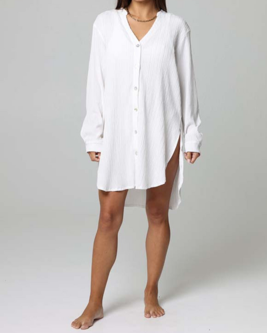 Model wearing a long sleeve button up oversized cover up shirt in white