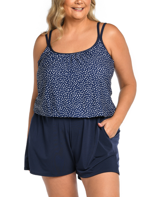 Plus size model wearing a swim romper with pockets in a navy and white dot print