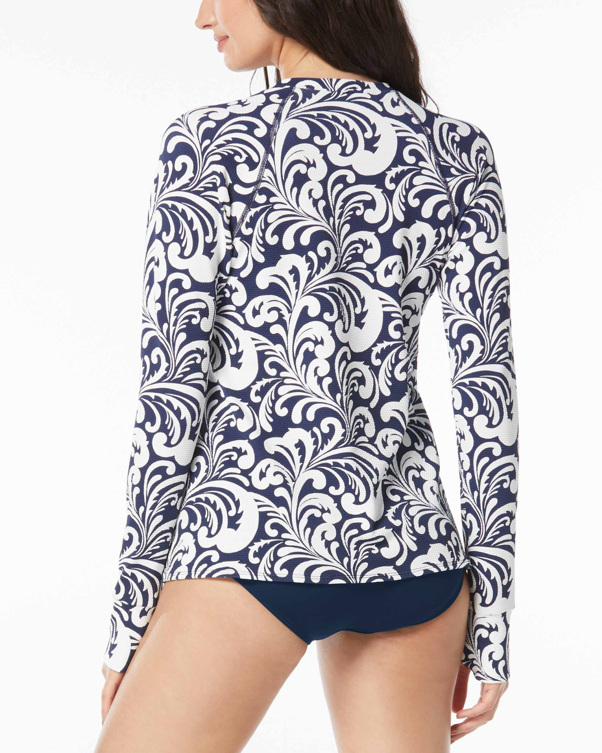 Model wearing a piqued fabric relaxed fit rash guard in a navy and white scroll print