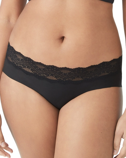 Front view of the bottom half of a model on white backdrop wearing a black hipster panty. The front of the panty has lace scalloped detail on the band.