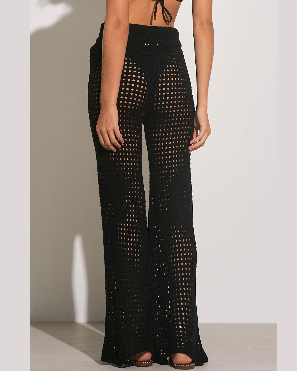 Model wearing a crochet pant cover up in black