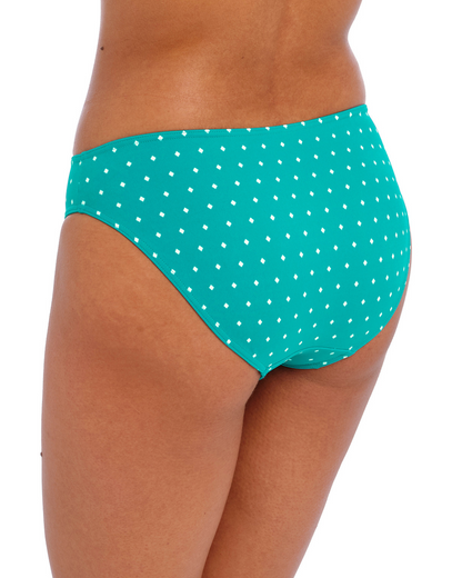 Model wearing a bikini brief bottom in a white dot and turquoise base print