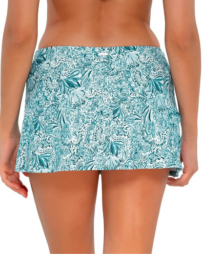 Model wearing a swim skirt with side pocket and hidden shorts in a pale turquoise, white and navy paisley print