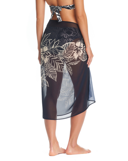 Model wearing a pareo cover up with a black base and white tropical Hawaiian floral detail