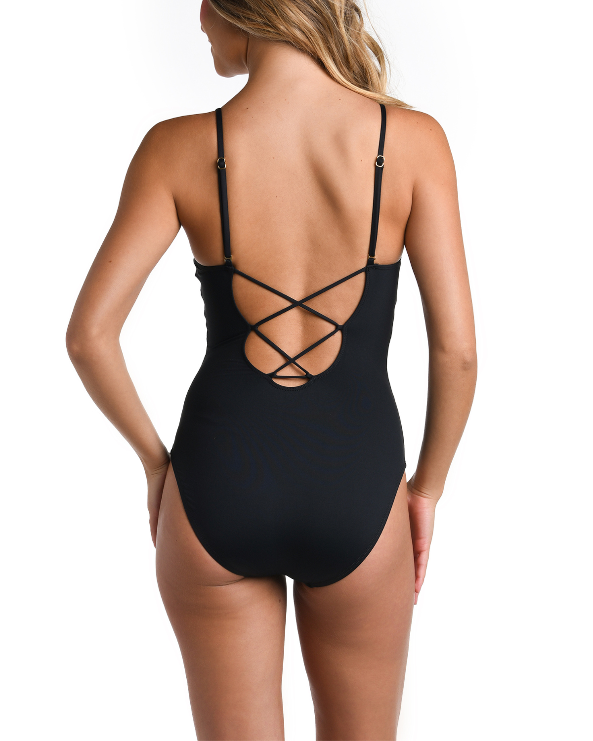 Model wearing a front plunge strappy back one piece in black with a floral print on the top half
