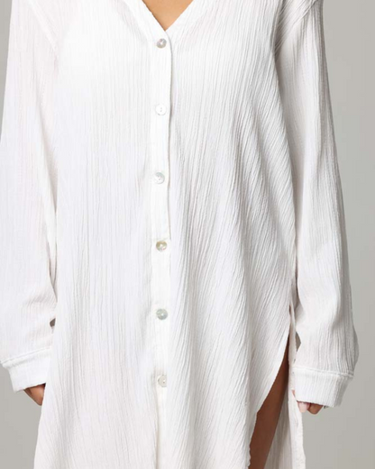 Model wearing a long sleeve button up oversized cover up shirt in white