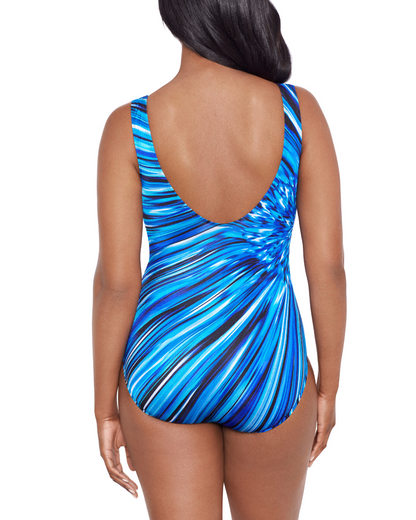 Model wearing a scoop back tank one piece in a blue, navy, black and white striped print