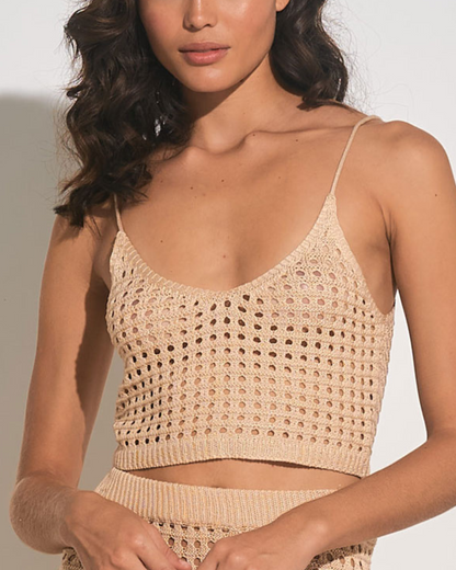 Model wearing a cropped crochet top in tan