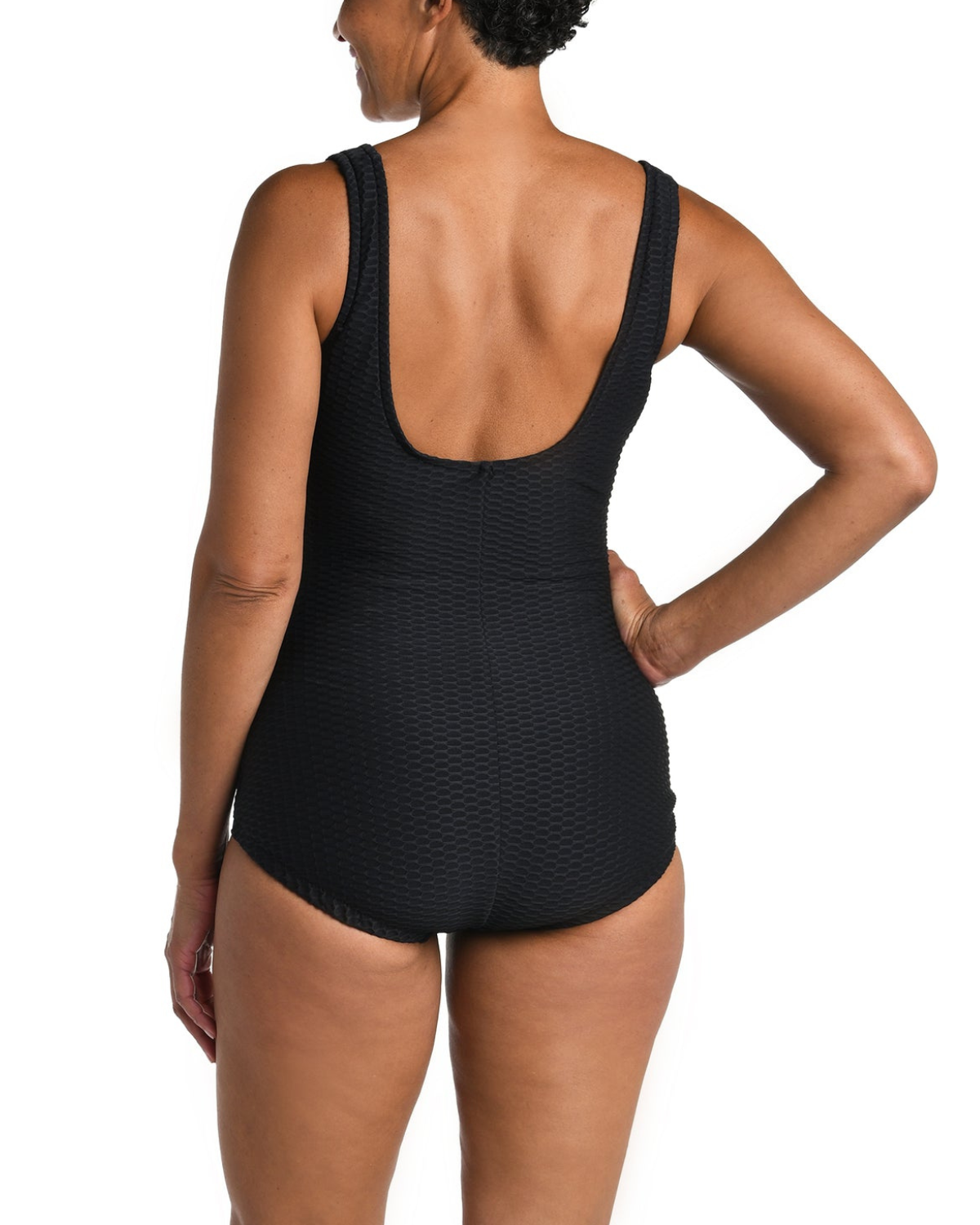 Model wearing a textured one piece swimsuit with a girl leg cut in black